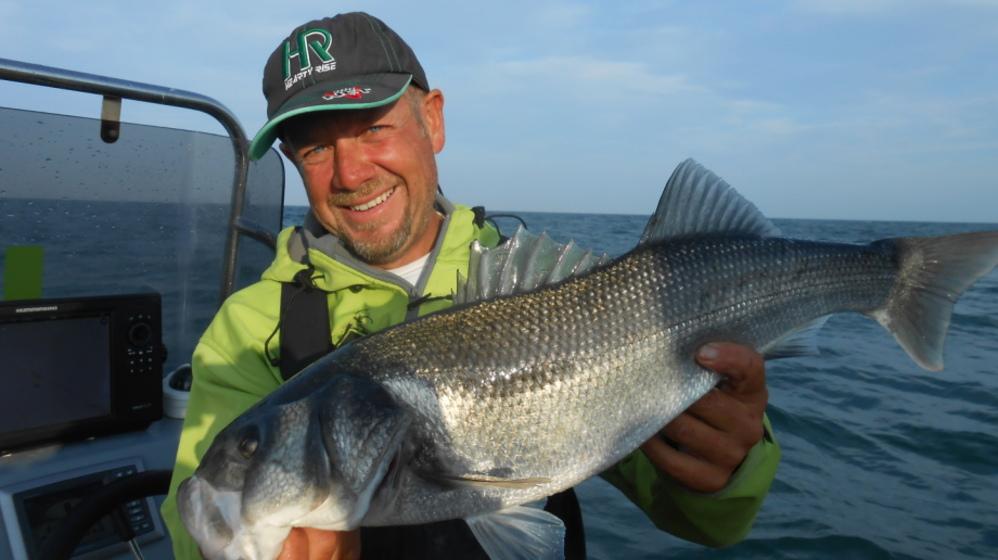 Homme tenant un poisson dans ses mains