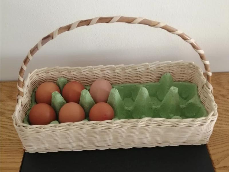 Un panier en osier contenant 12 oeufs