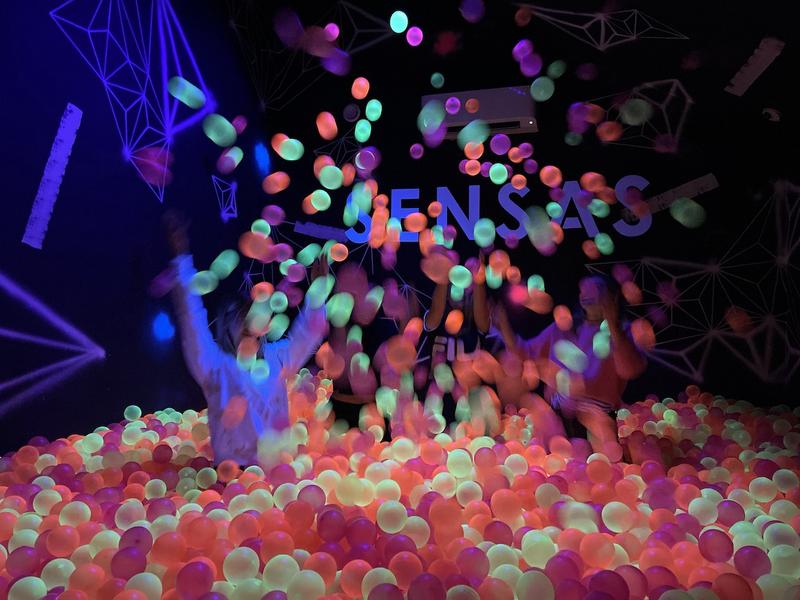 Une personne lancant en l'air des boules en plastiques de la piscine de boules