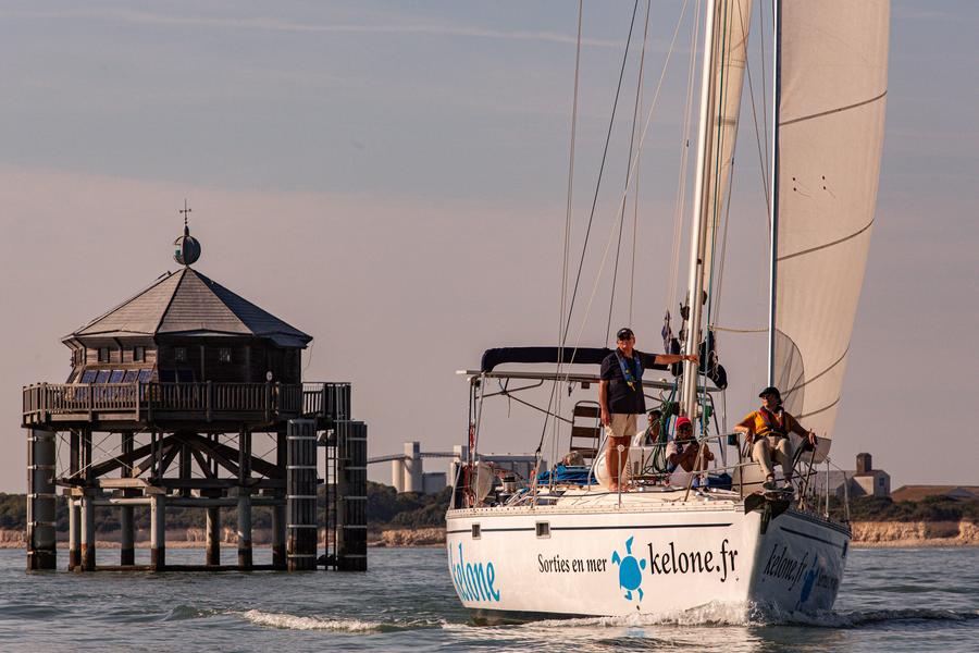 Voilier Kelone passant près du phare du bout du monde